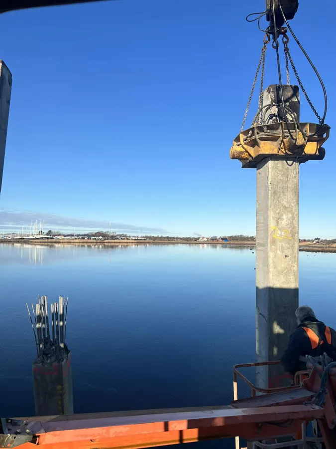 Betonpæl håndteres ved havnekonstruktion